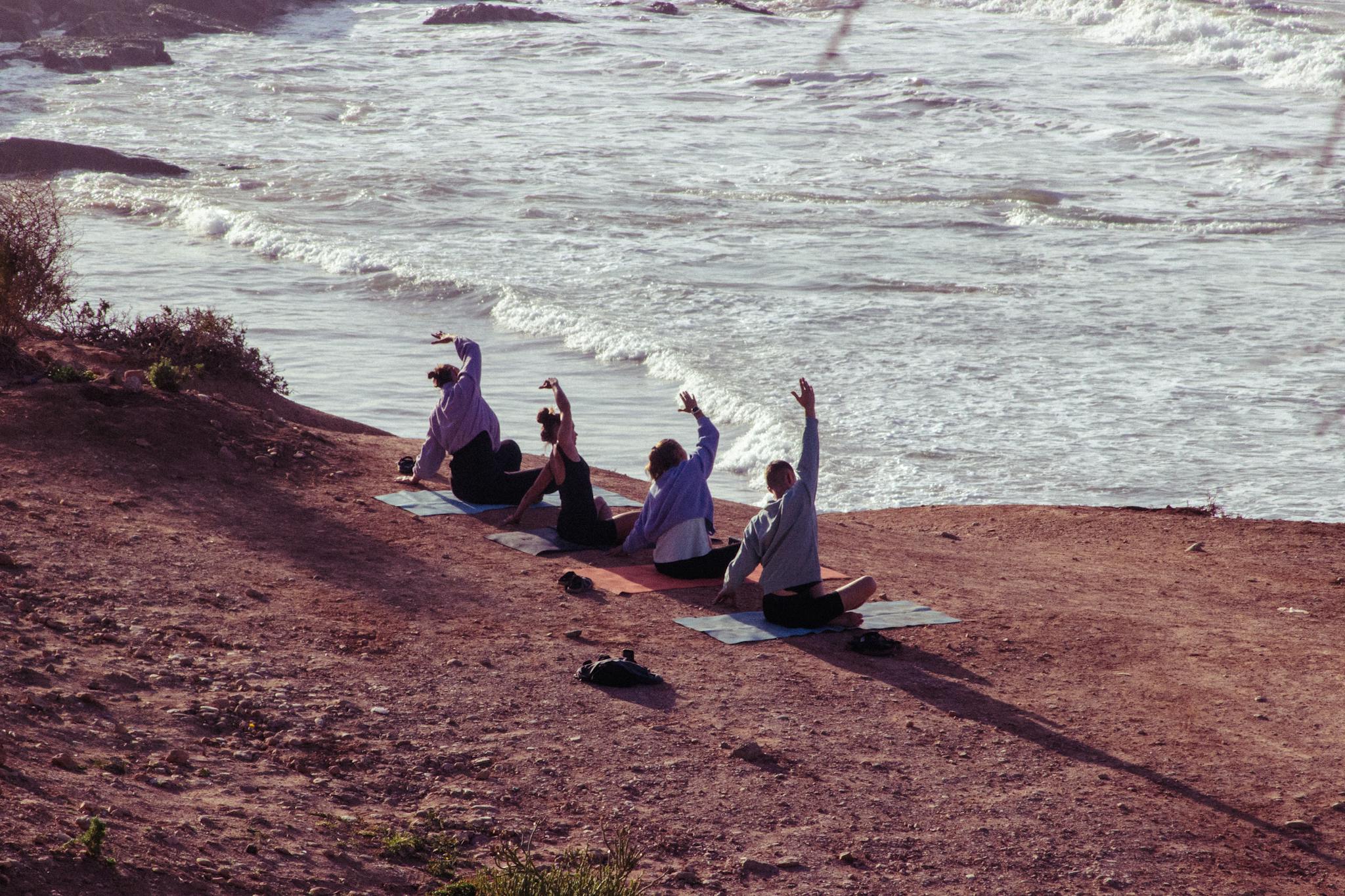 A peaceful outdoor yoga session by the ocean in Morocco, with a warm and earthy tone.